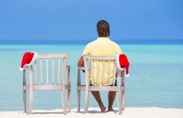 Back view of young man on beach chair with santa hat during beach vacation — Stock Photo, Image