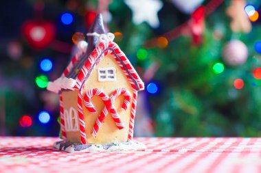 Çelenkli parlak Noel ağacının arka planında zencefilli kek evi