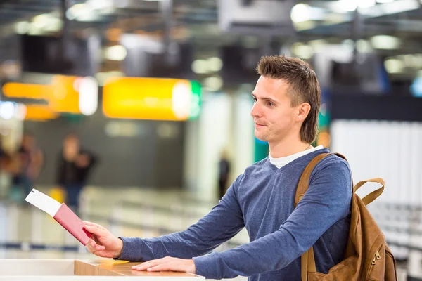 Joven con pasaportes y tarjetas de embarque en la recepción del aeropuerto — Foto de Stock