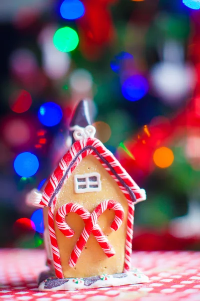 Lebkuchenmärchenhaus auf dem Hintergrund eines hellen Weihnachtsbaums mit Girlande — Stockfoto