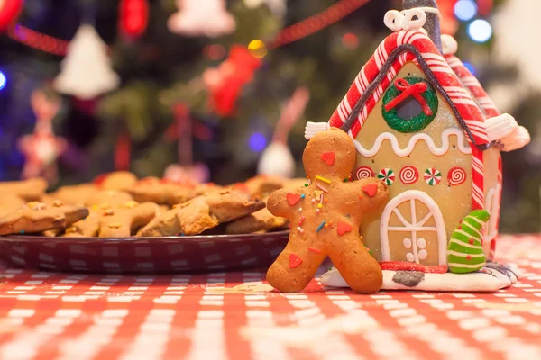 Carino pan di zenzero uomo e caramelle casa zenzero sfondo albero di Natale luci — Foto Stock