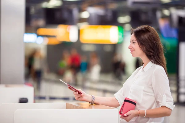 Glückliche Frau mit Flugticket und Reisepass am Flughafen, die auf das Boarding wartet — Stockfoto
