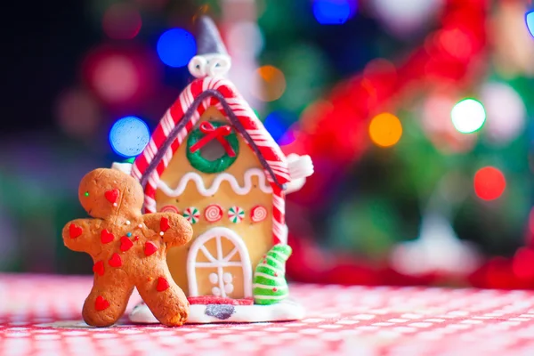 Cute gingerbread man and candy ginger house background Christmas tree lights — Stock Photo, Image