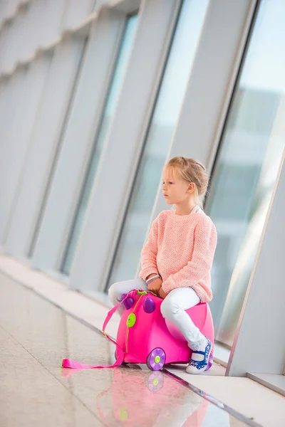 Söt liten flicka på flygplatsen med sitt bagage väntar på ombordstigning — Stockfoto
