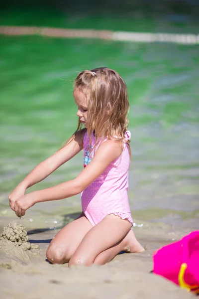 Adorable niña jugando con juguetes de playa durante las vacaciones tropicales — Foto de Stock