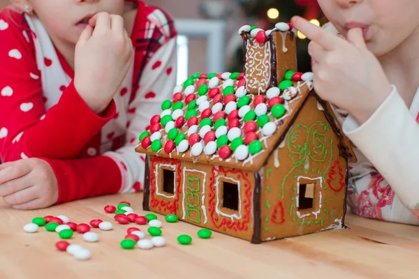 Little adorable girls decorating gingerbread house for Christmas — Stock Photo, Image