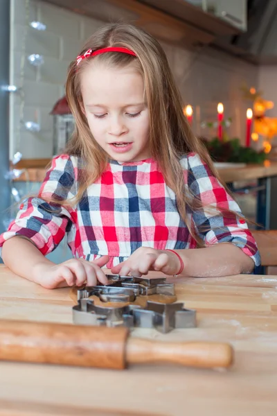 Kleines entzückendes Mädchen backt Weihnachtsplätzchen zu Hause — Stockfoto