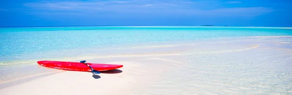 Turkuaz su ile beyaz kum plajındaki kırmızı sörf tahtası — Stok fotoğraf