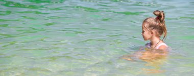 Yaz tatili boyunca sahilde sevimli küçük bir kız.