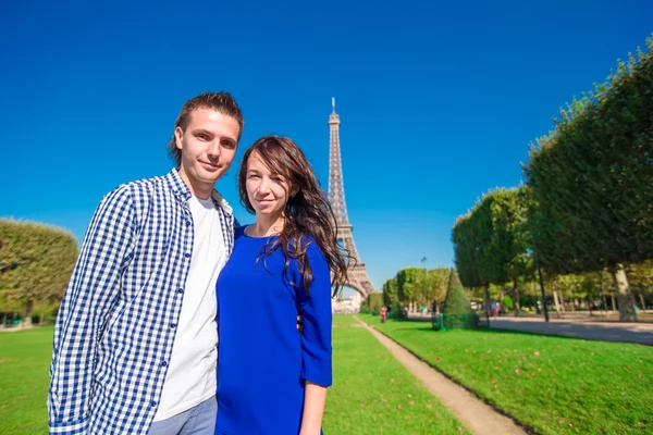 Jeune couple heureux sur le Champ de Mars à Paris fond la Tour Eiffel — Photo