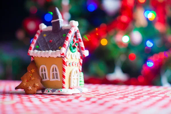 Cute gingerbread cookie and candy ginger house background Christmas tree lights — Stock Photo, Image