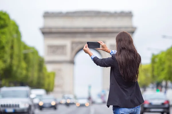 Młoda kobieta robienie zdjęć z jej telefon na Champs Elysees w Paryżu — Zdjęcie stockowe