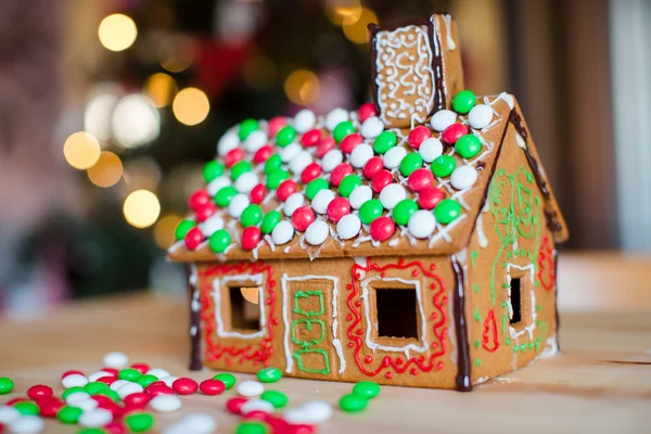Galleta de jengibre y caramelo casa de jengibre fondo árbol de Navidad luces — Foto de Stock