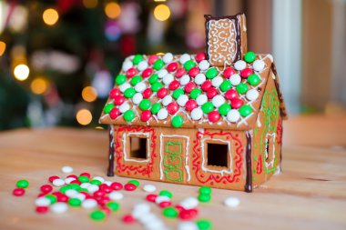 Gingerbread house renkli şekerler arka plan Noel ağacı ışıkları ile dekore edilmiştir.
