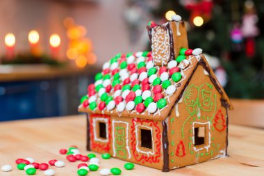 Gingerbread house renkli şekerler arka plan Noel ağacı ışıkları ile dekore edilmiştir.