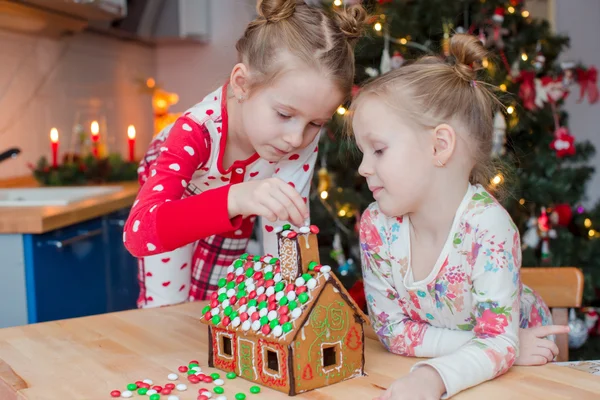 Niñas adorables decorando casa de jengibre para Navidad — Foto de Stock