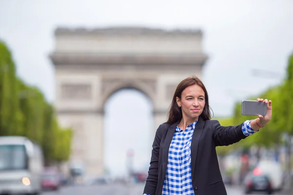 Mujer joven tomando selfie con su teléfono en los Campos Elíseos de París — Foto de Stock