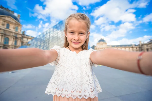 Adorable niña tomando selfie con teléfono móvil al aire libre en París —  Fotos de Stock