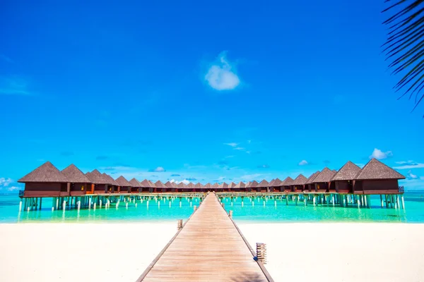 Bungalow acquatici e pontile di legno sull'isola tropicale nell'Oceano Indiano — Foto Stock