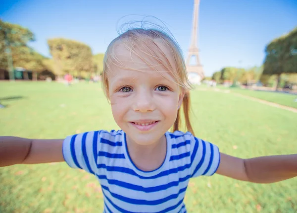 Adorable niña tomando selfie por teléfono cerca de la torre Eiffel al aire libre — Foto de Stock