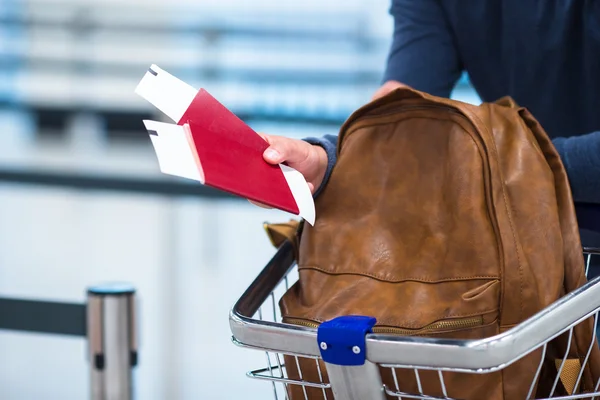 Passaporte e bilhete de embarque e uma mochila nos carrinhos de bagagem — Fotografia de Stock