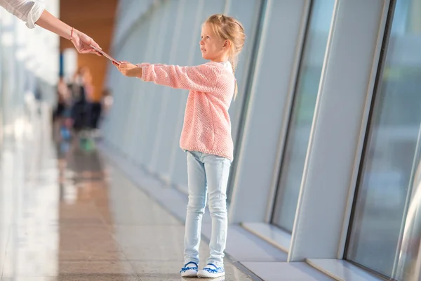 Adorable niña con tarjeta de embarque en el aeropuerto esperando el vuelo —  Fotos de Stock
