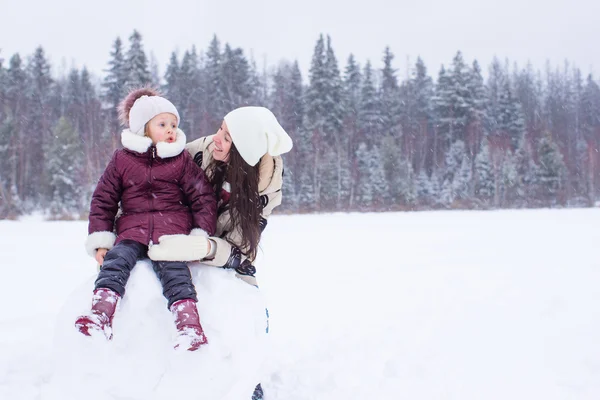 Menina ang mãe feliz desfrutar de inverno dia nevado — Fotografia de Stock
