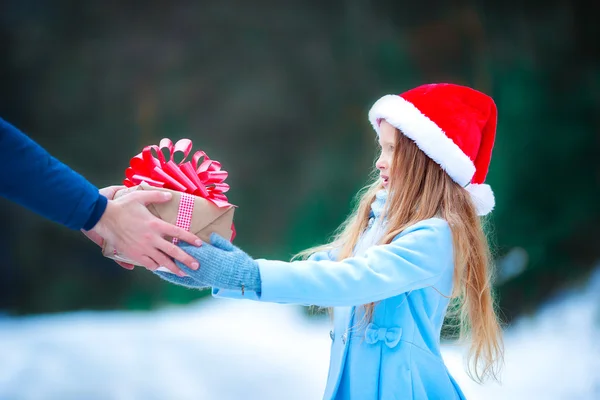 Adorable petite fille donnant cadeau de boîte de Noël en hiver en plein air — Photo