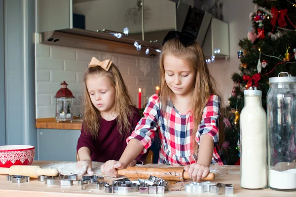 女の子の家庭の台所にクリスマスのジンジャーブレッドのクッキーを焼く — ストック写真