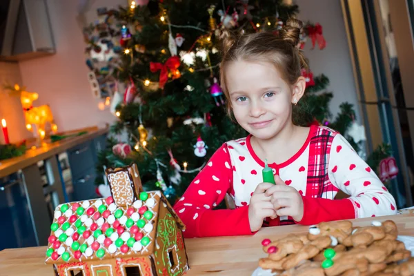 Schattig meisje koken peperkoek huis voor Kerstmis — Stockfoto