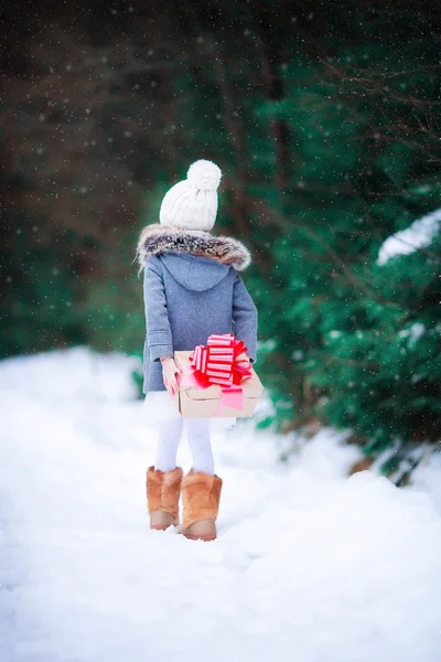 Schattig meisje met Kerstmis vak gift in winter buiten — Stockfoto