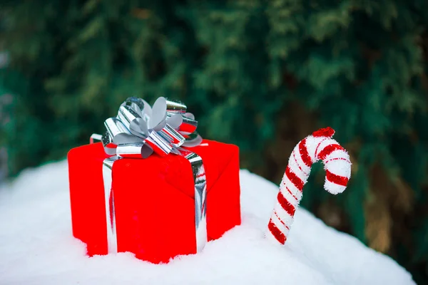 Regalo di Natale rosso e caramelle sulla neve all'aperto — Foto Stock