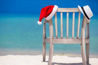 Noel kavramı: plaj sandalyeleri kırmızı Santa ve hasır şapkalar ile arka plan güzel turkuaz deniz