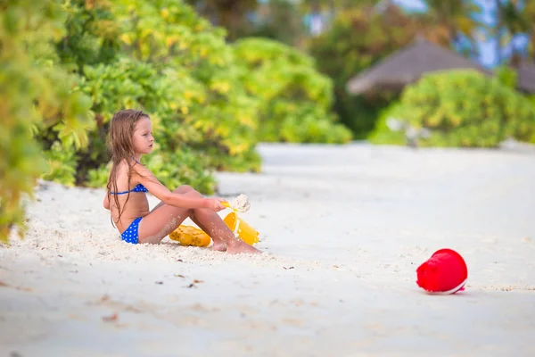 Adorable niña jugando con juguetes de playa durante las vacaciones tropicales —  Fotos de Stock