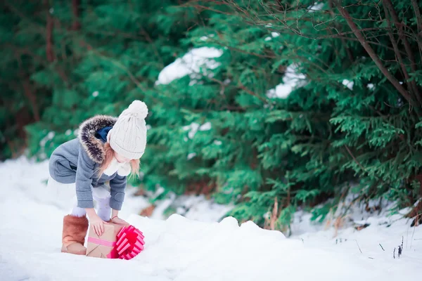 Little girl with Christmas box gift in winter outdoors on Xmas eve — Stock Photo, Image