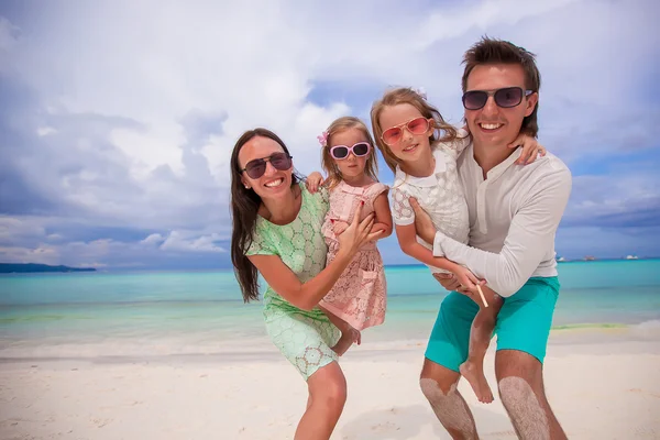 Família jovem de quatro em férias de praia — Fotografia de Stock