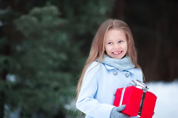 Adorable niña con regalo de caja de Navidad en invierno al aire libre en Nochebuena — Foto de Stock