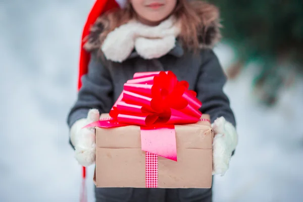 Adorabile bambina con regalo di Natale scatola in giorno d'inverno all'aperto — Foto Stock