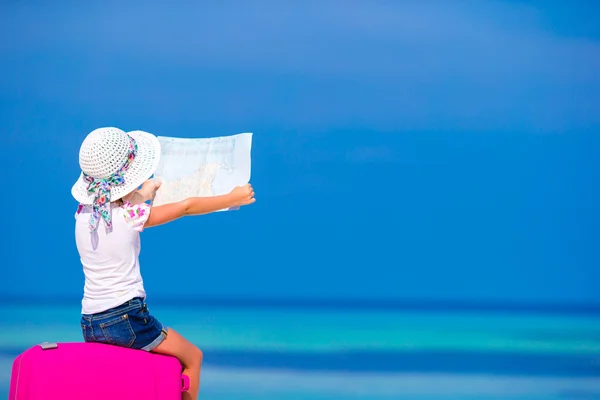Little adorable girl with big luggage and mapduring beach vacation — Stock Photo, Image
