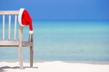 Noel kavramı. Kırmızı santa şapka tropikal beyaz Beach.