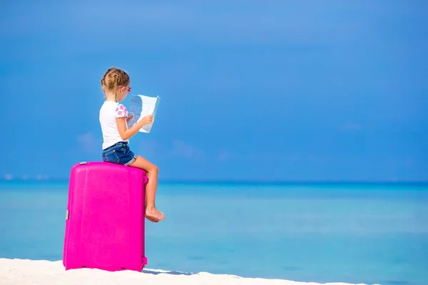 Adorable girl with big luggage and map of island on white beach — Stock Photo, Image