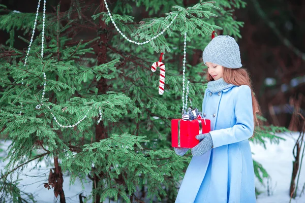 Bedårande liten flicka med jul box gåva i vinter utomhus — Stockfoto