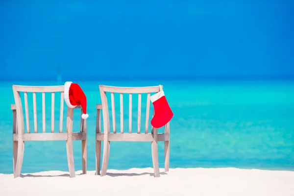 Meia de Natal vermelho e chapéu de Santa na praia tropical — Fotografia de Stock