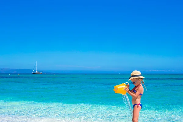 Очаровательная маленькая девочка играет с пляжными игрушками во время тропического отпуска — стоковое фото
