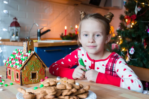 Adorable chica horneando galletas de Navidad en Nochebuena. Árbol de Navidad y luces en el fondo . — Foto de Stock