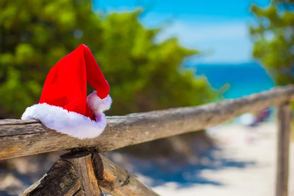 Red Santas hat on a wooden fence outdoors — Stock Photo, Image