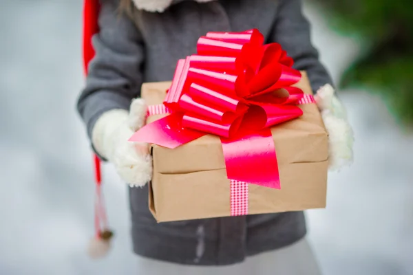 Adorabile bambina con regalo di Natale scatola in giorno d'inverno all'aperto — Foto Stock