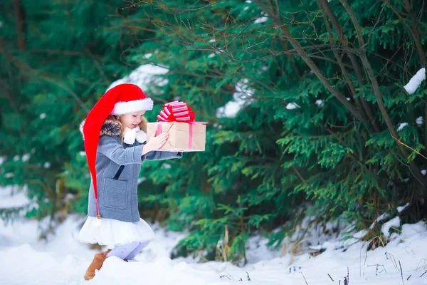 可爱的小女孩，在冬天天户外圣诞盒礼物 — 图库照片