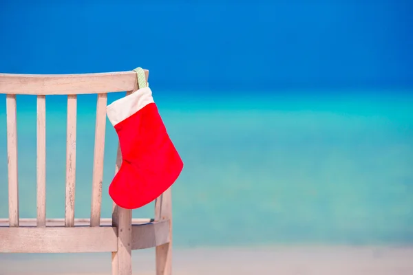 Bas de Noël rouge sur chaise longue à la plage de blanc tropical — Photo