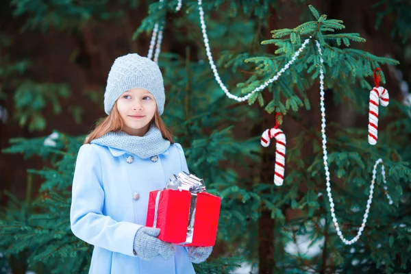 Adorable petite fille avec cadeau de boîte de Noël en hiver à l'extérieur la veille de Noël — Photo